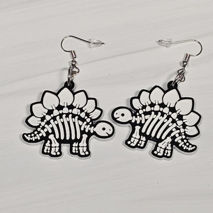 Dinosaur skeleton earrings on a light gray background