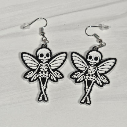 Skeletal fairy earrings on a light gray background