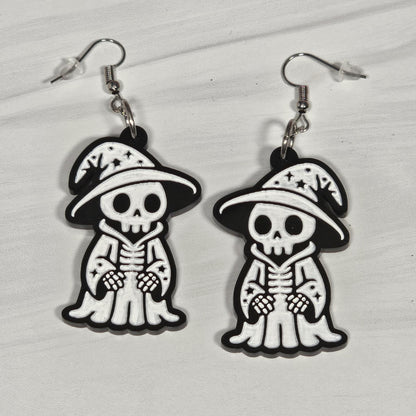Pair of wizard skeleton earrings with hats on a light gray background