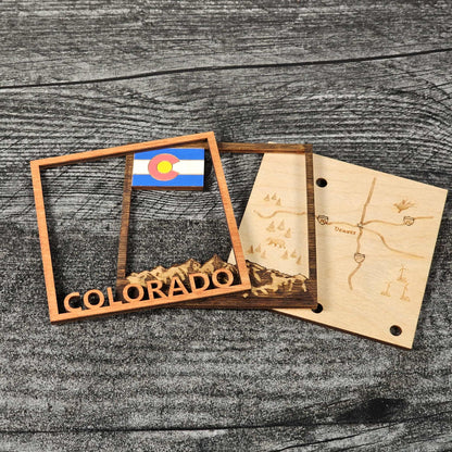 Wooden Colorado-themed items including a map and a flag on a wooden surface