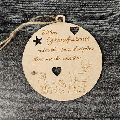 Wooden round ornament with engraved text and animal illustrations on a dark textured background