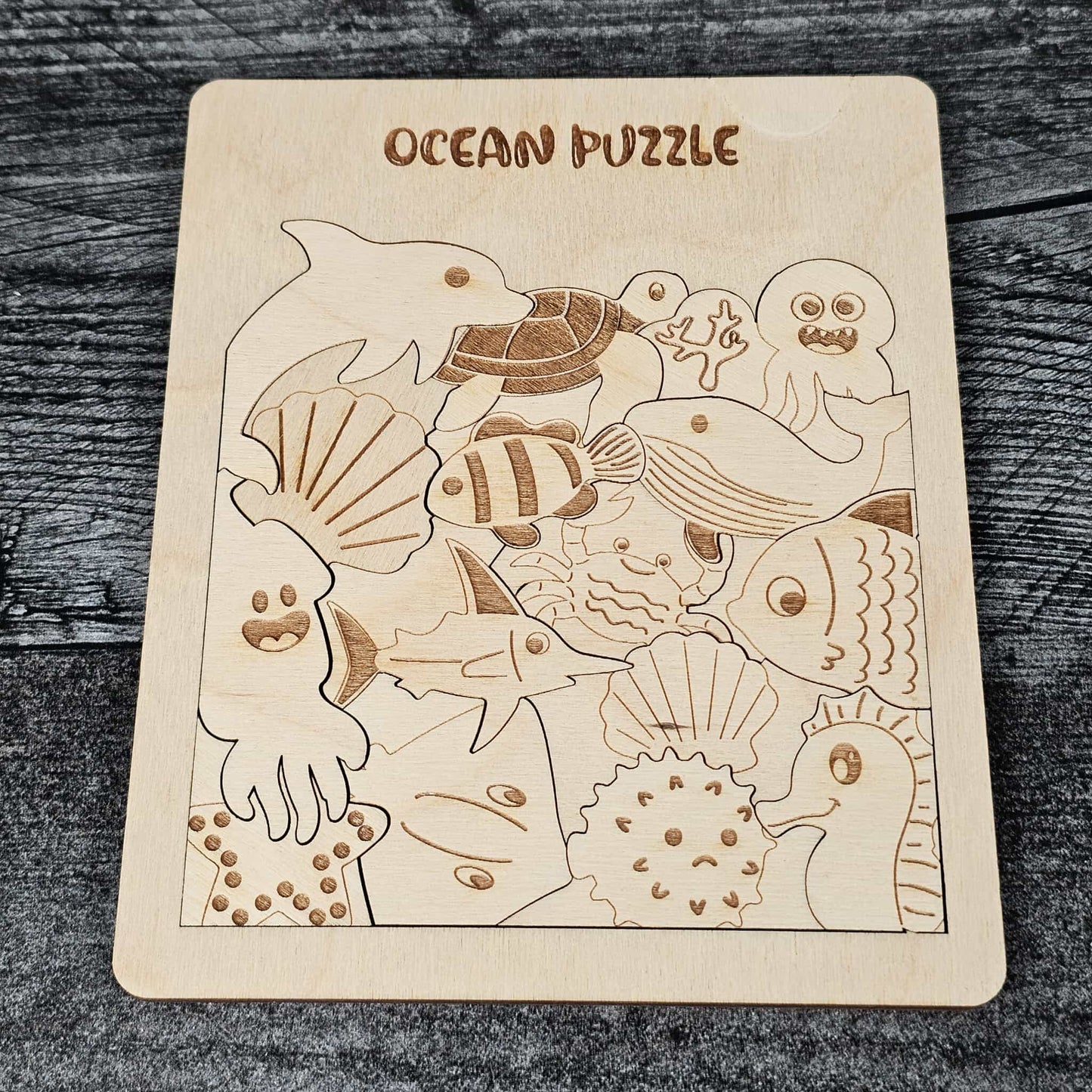 Wooden ocean puzzle with various sea creatures on a wooden surface