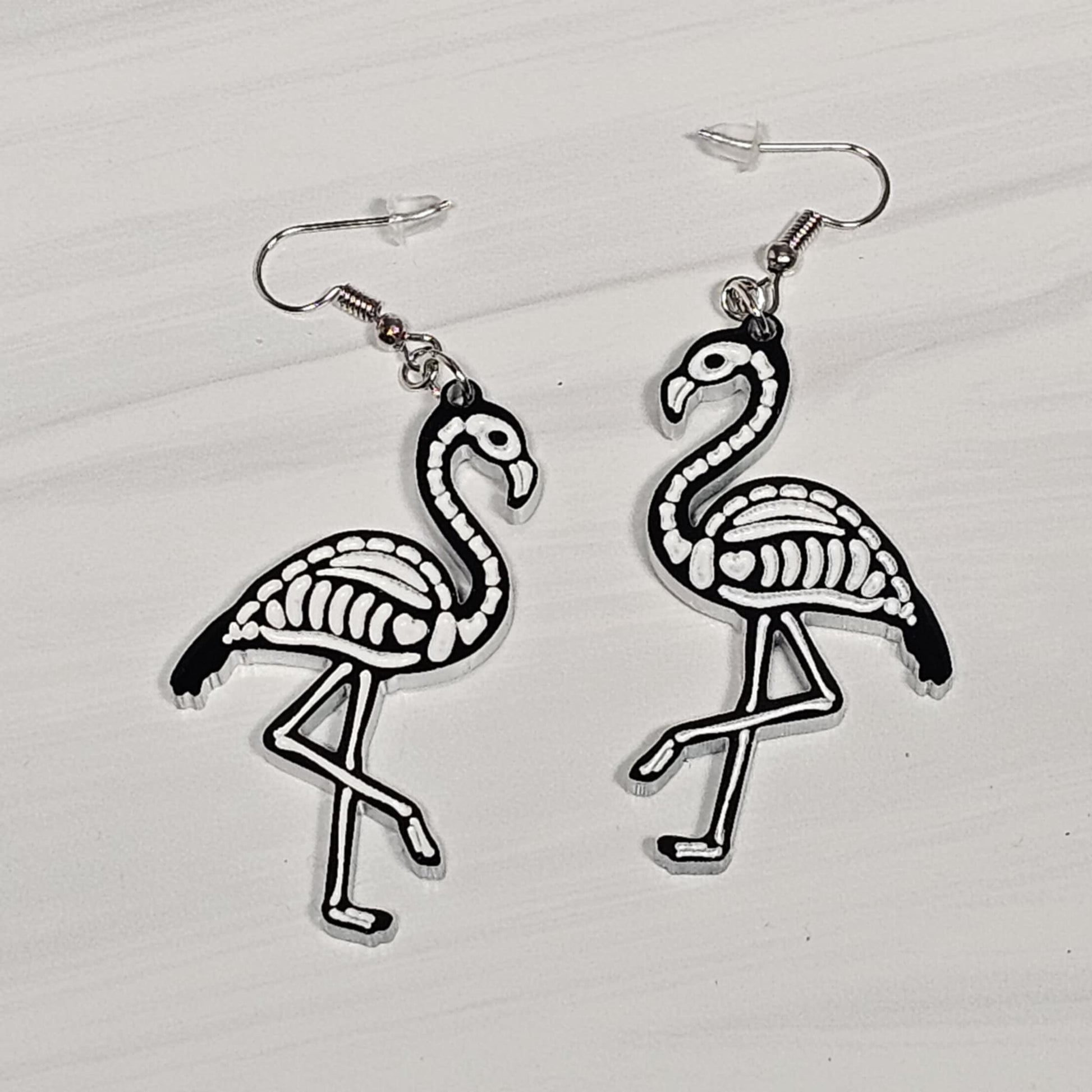 Flamingo skeleton earrings on a light gray background