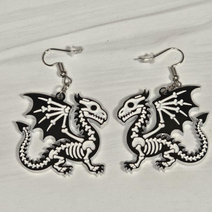 Dragon skeleton earrings on a light gray background