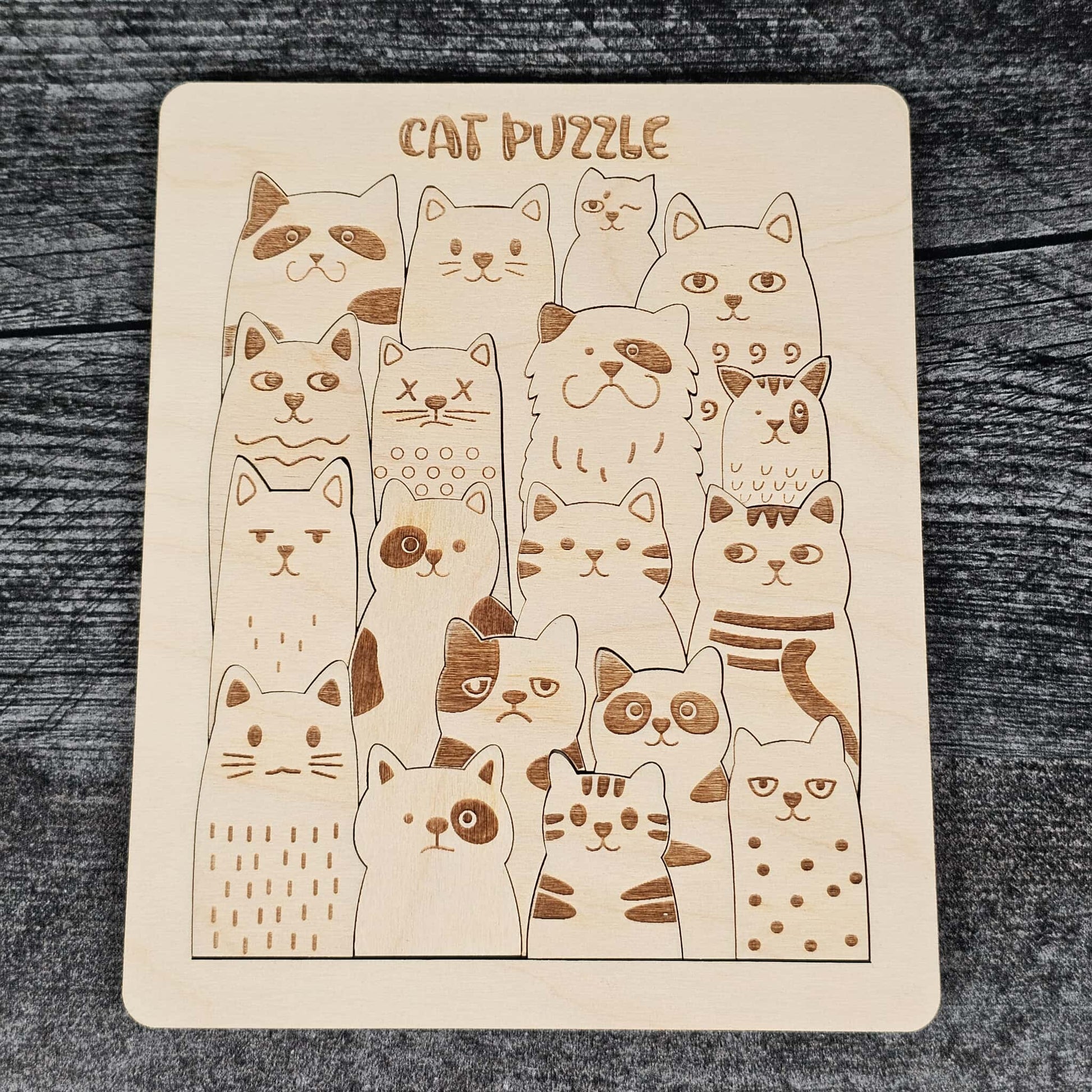 Cat puzzle with various cat illustrations on a wooden board.