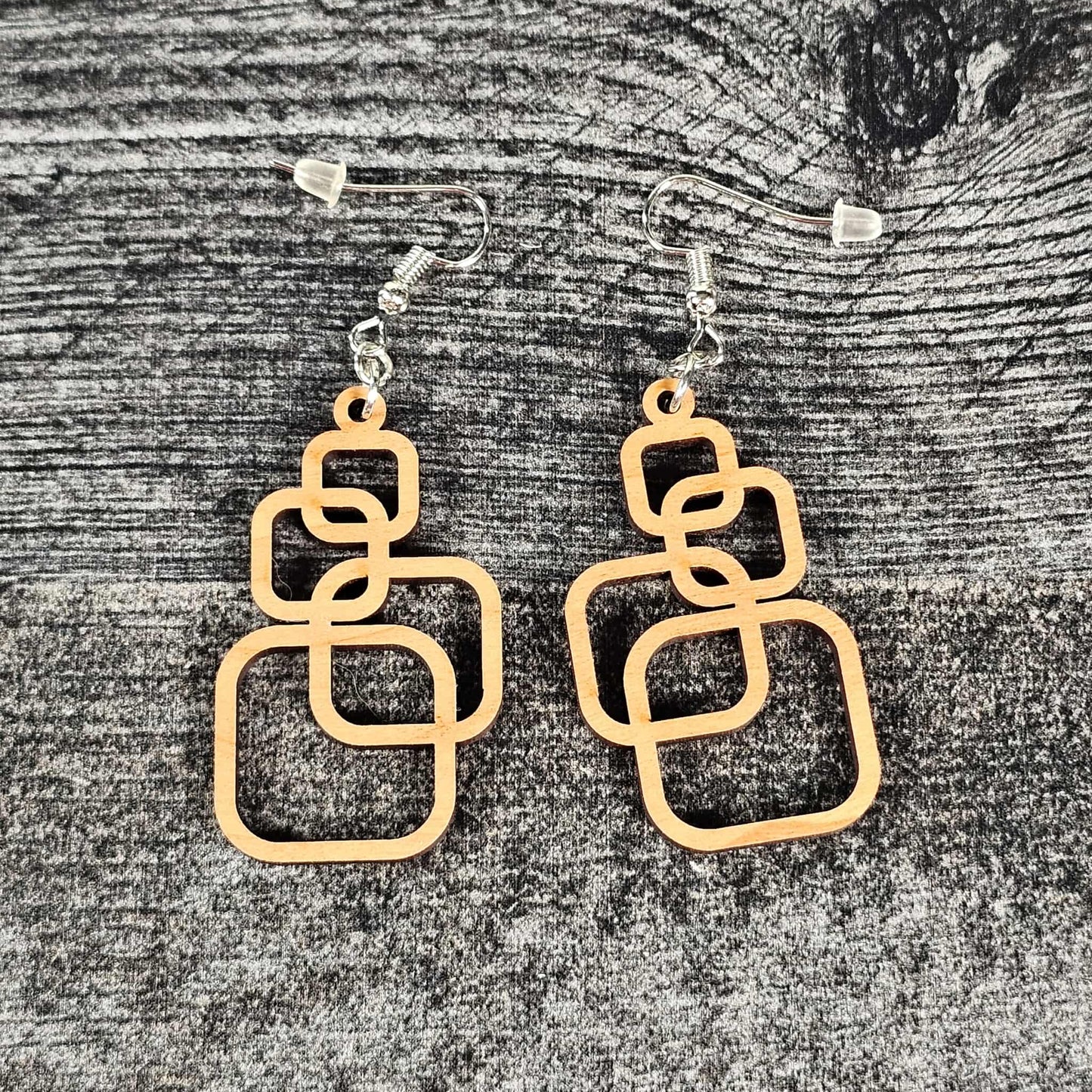 Cherry wooden geometric squares earrings on a textured gray surface