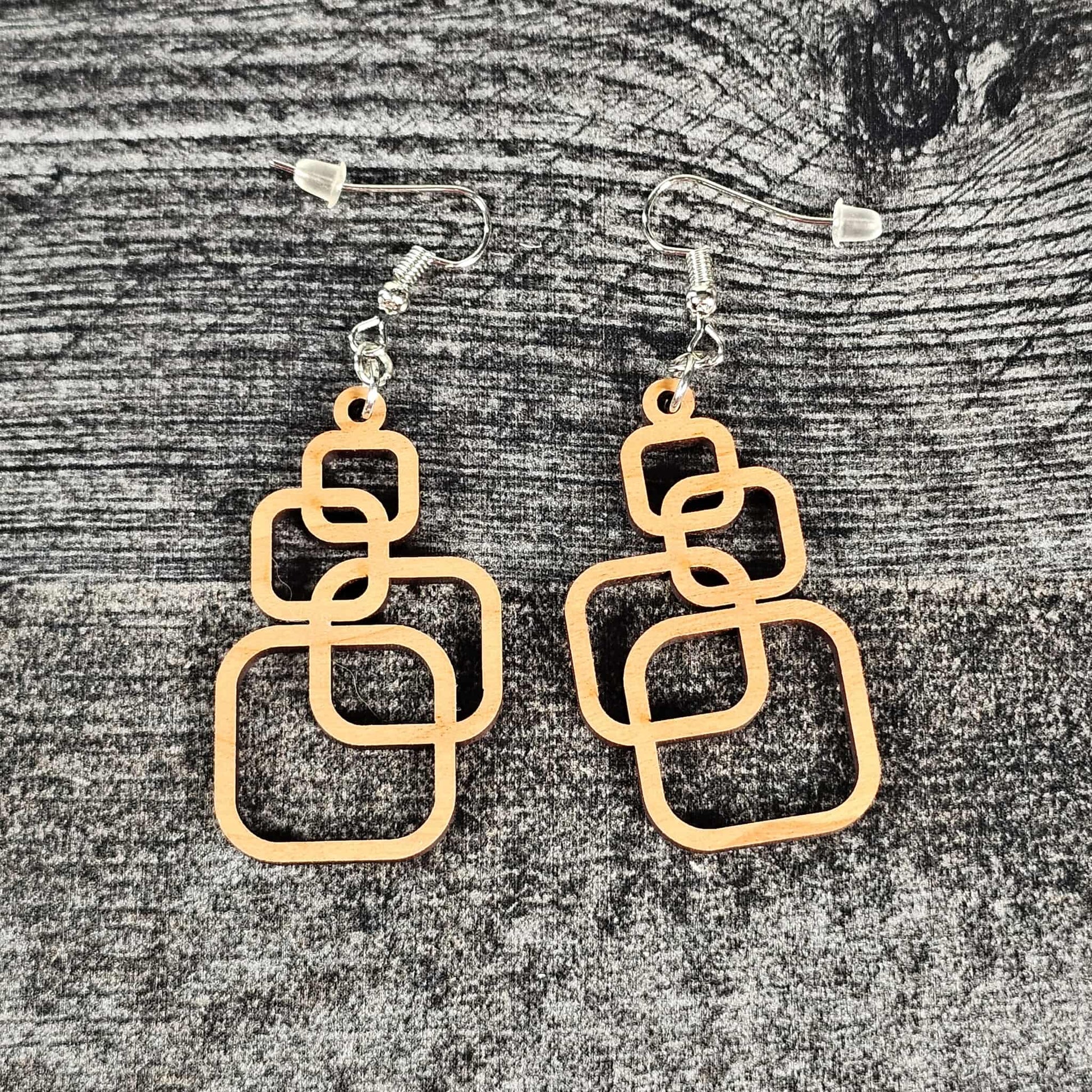 Cherry wooden geometric squares earrings on a textured gray surface