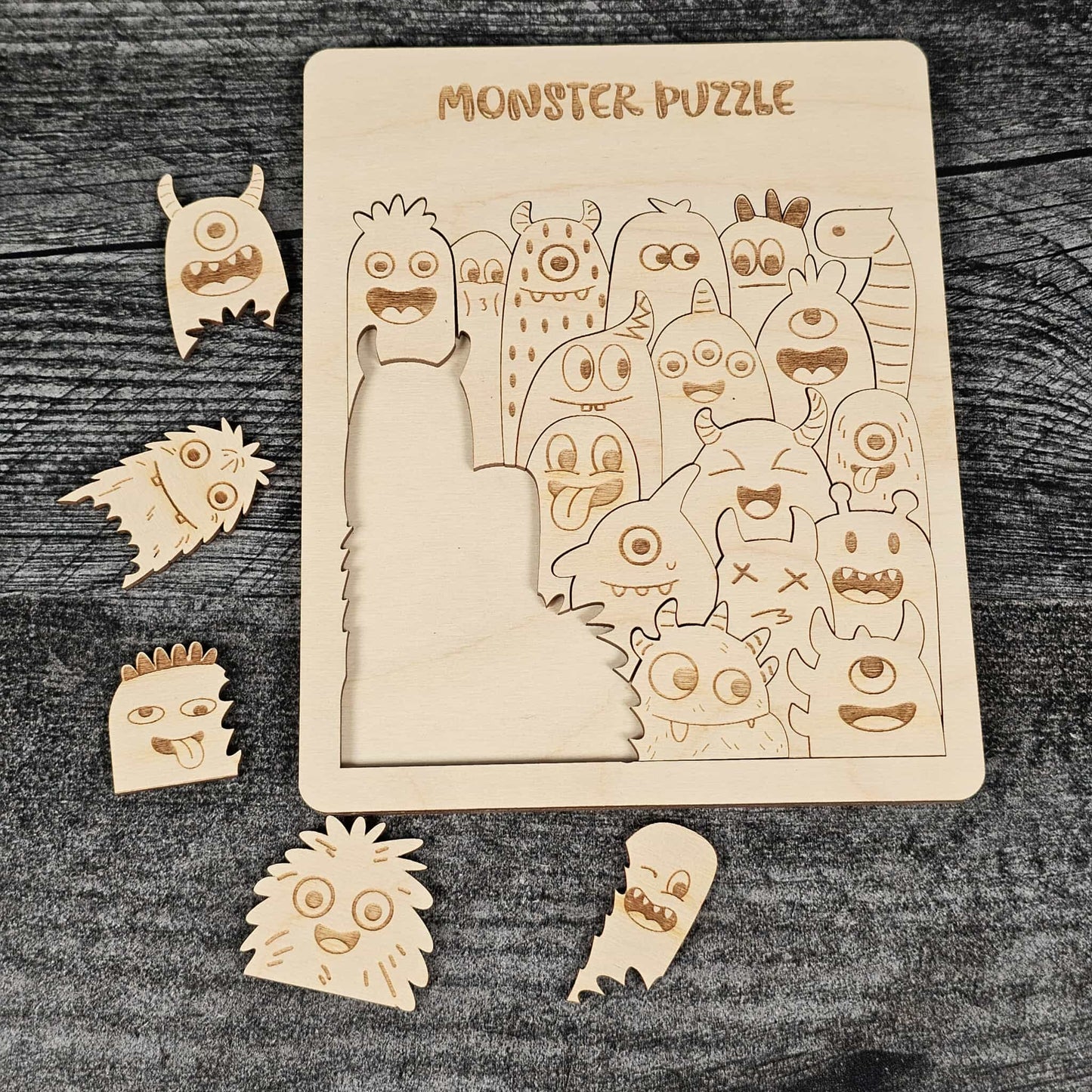 Wooden monster puzzle with pieces on a dark wooden surface