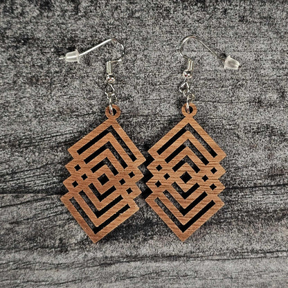 Walnut wood geometric diamond patterned earrings on a textured gray surface