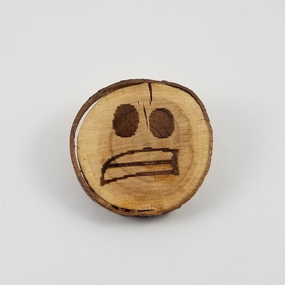 Wooden emoji with a nervous expression on a white background
