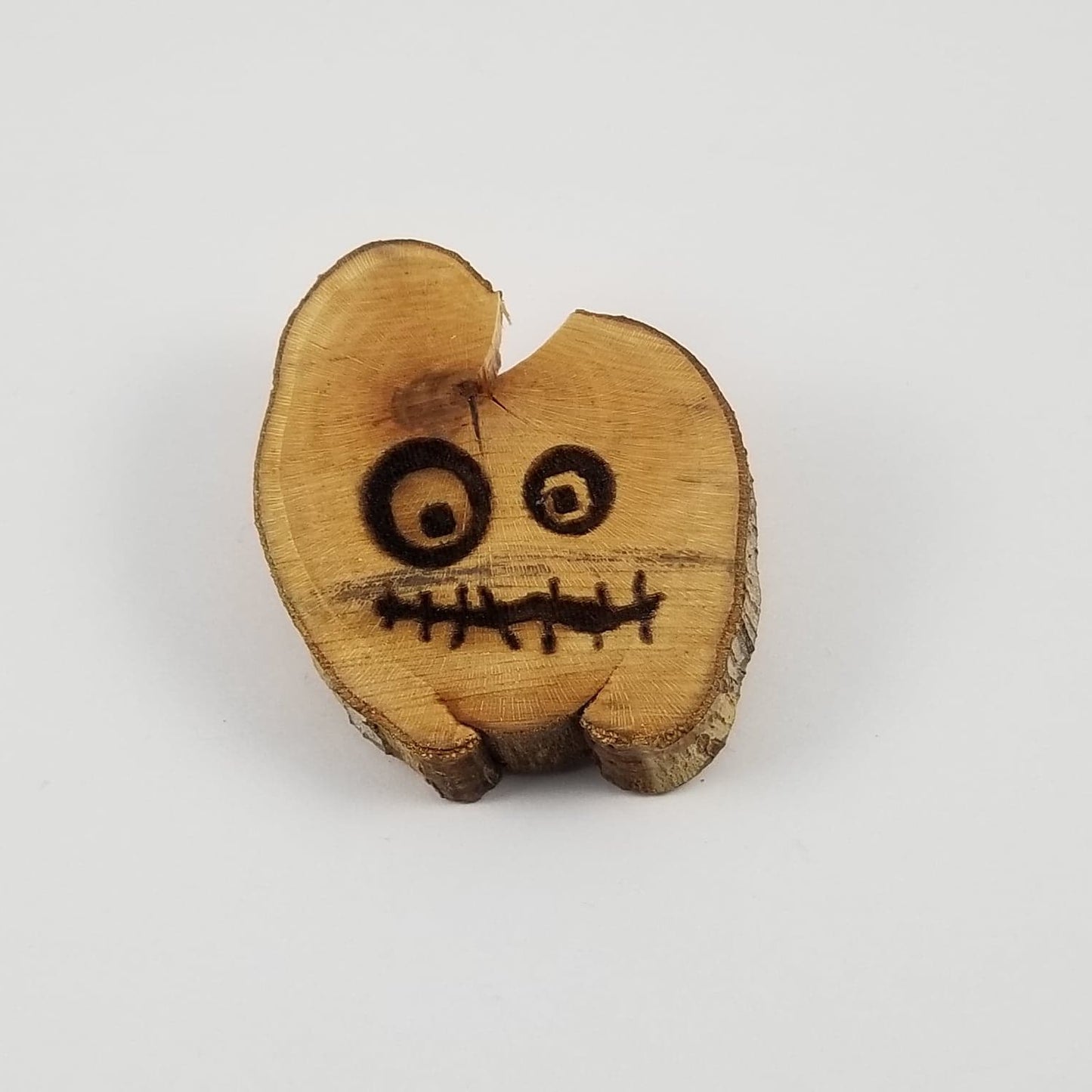 Wooden heart-shaped figurine with face on a white background