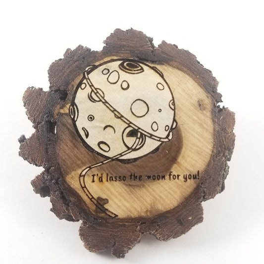 Wooden plaque with a moon illustration and text 'I'd lasso the moon for you!' on a white background