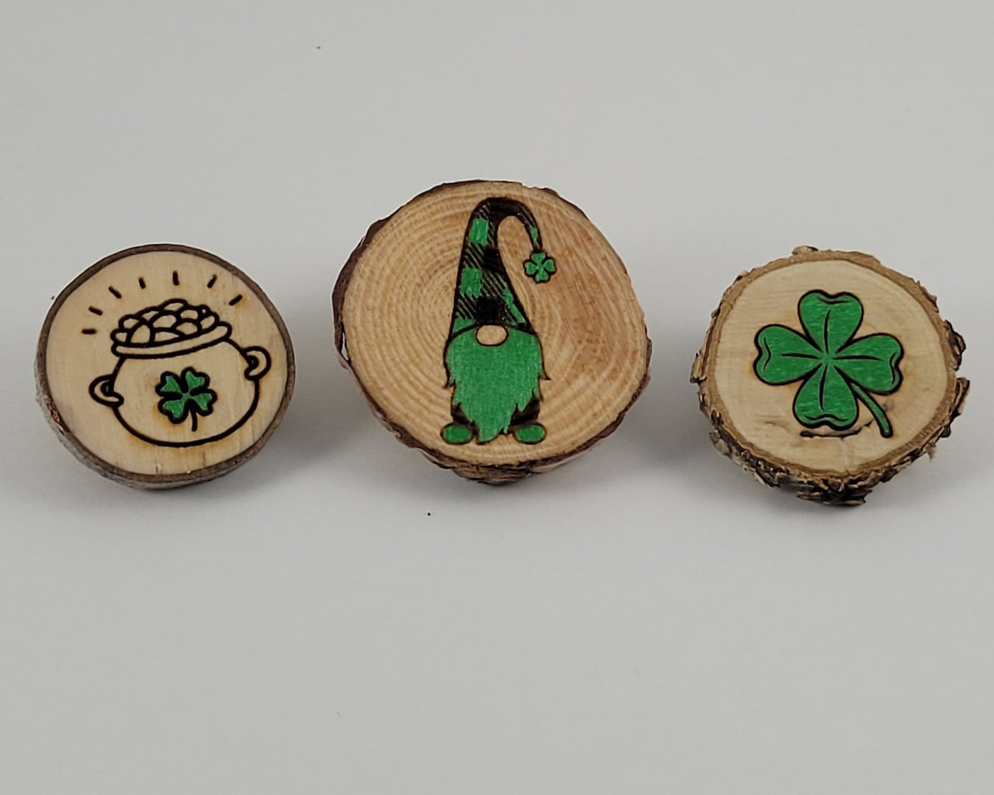 A set of three wooden magnets with St Patrick's Day themed designs, including a shamrock and a leprechaun.