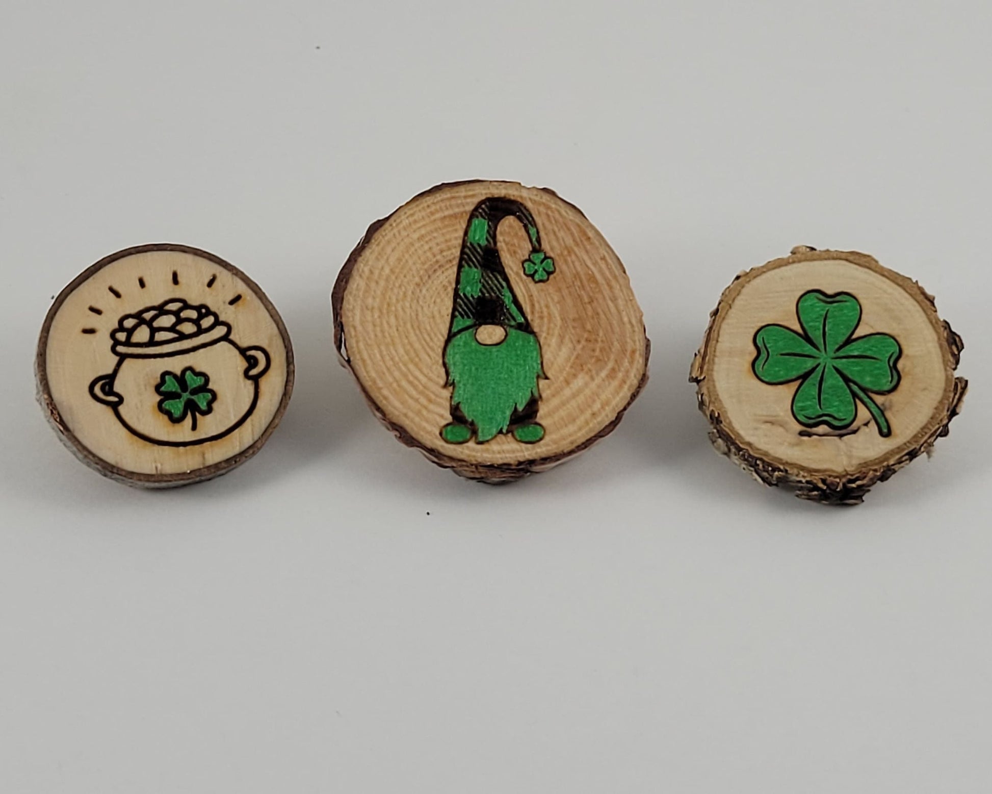 A set of three wooden magnets with St Patrick's Day themed designs, including a shamrock and a leprechaun.