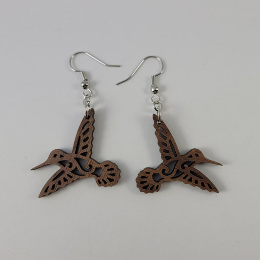A pair of brown walnut hummingbird earrings with silver fish hooks and silicone backing.