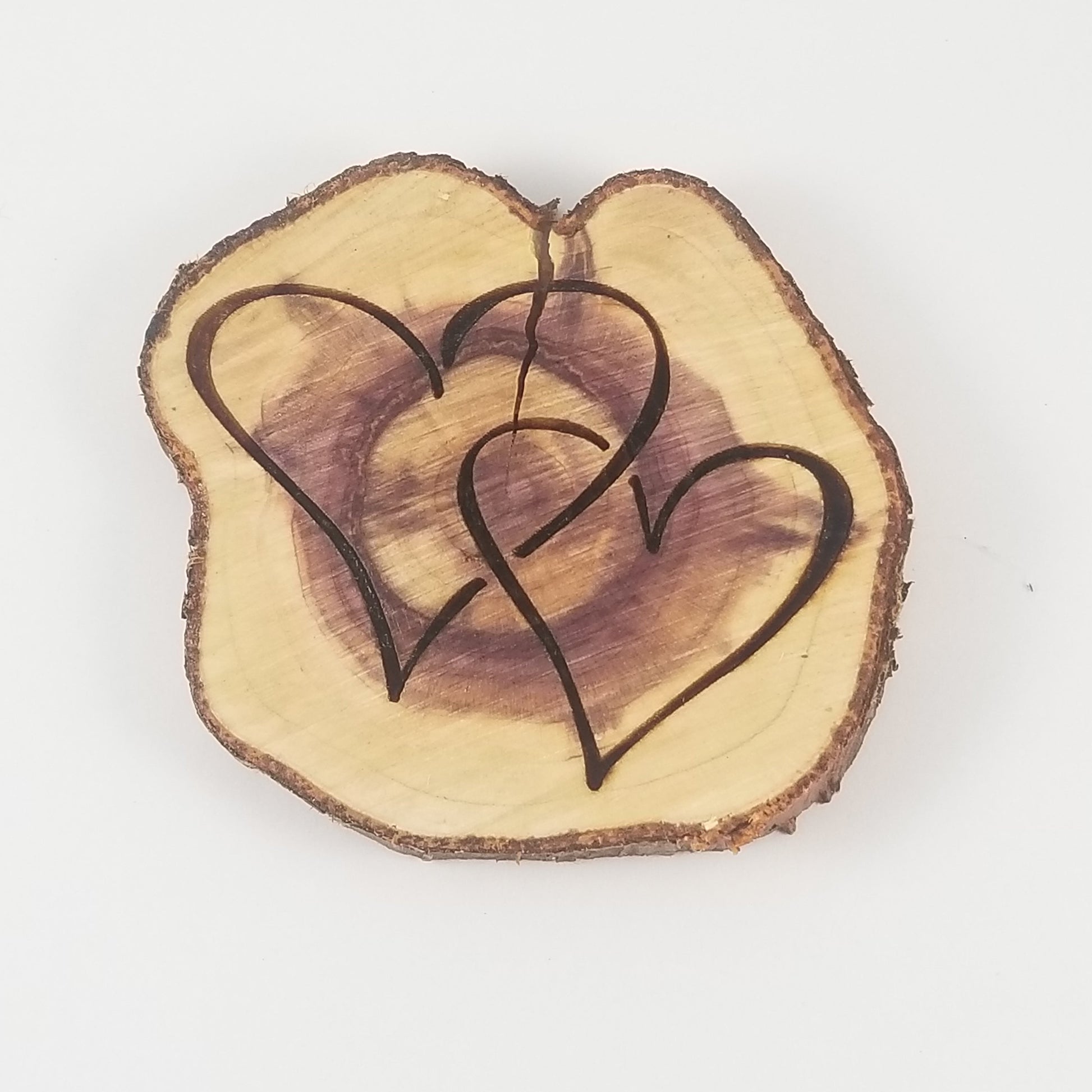 A double heart-shaped wooden ornament with a purple center, on a white background.