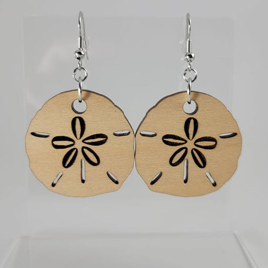 A pair of wood sand dollar earrings with silver fish hook settings and a silicone backing, displayed against a white background.