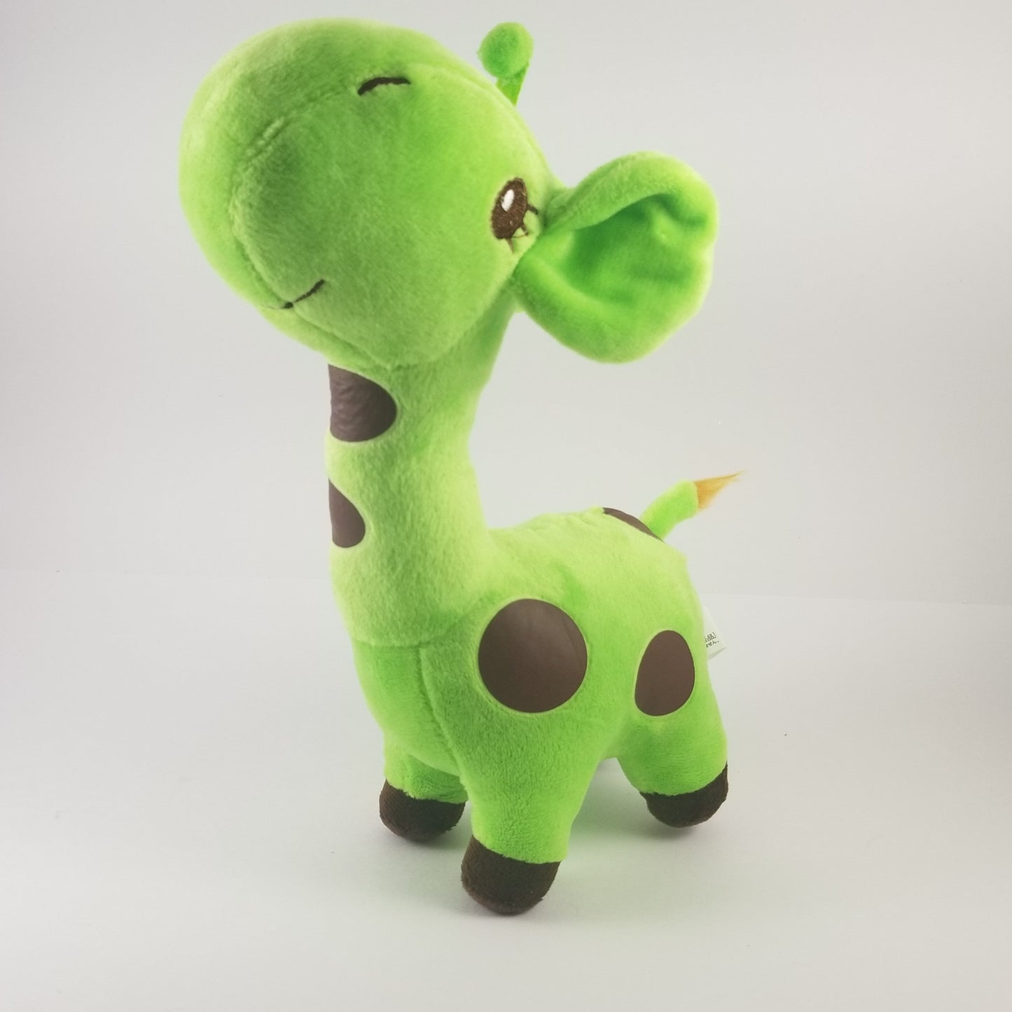 Green plush giraffe toy on a white background