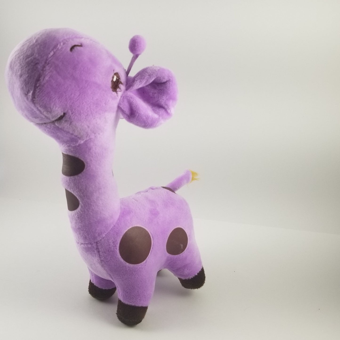 Purple plush giraffe toy on a light gray background