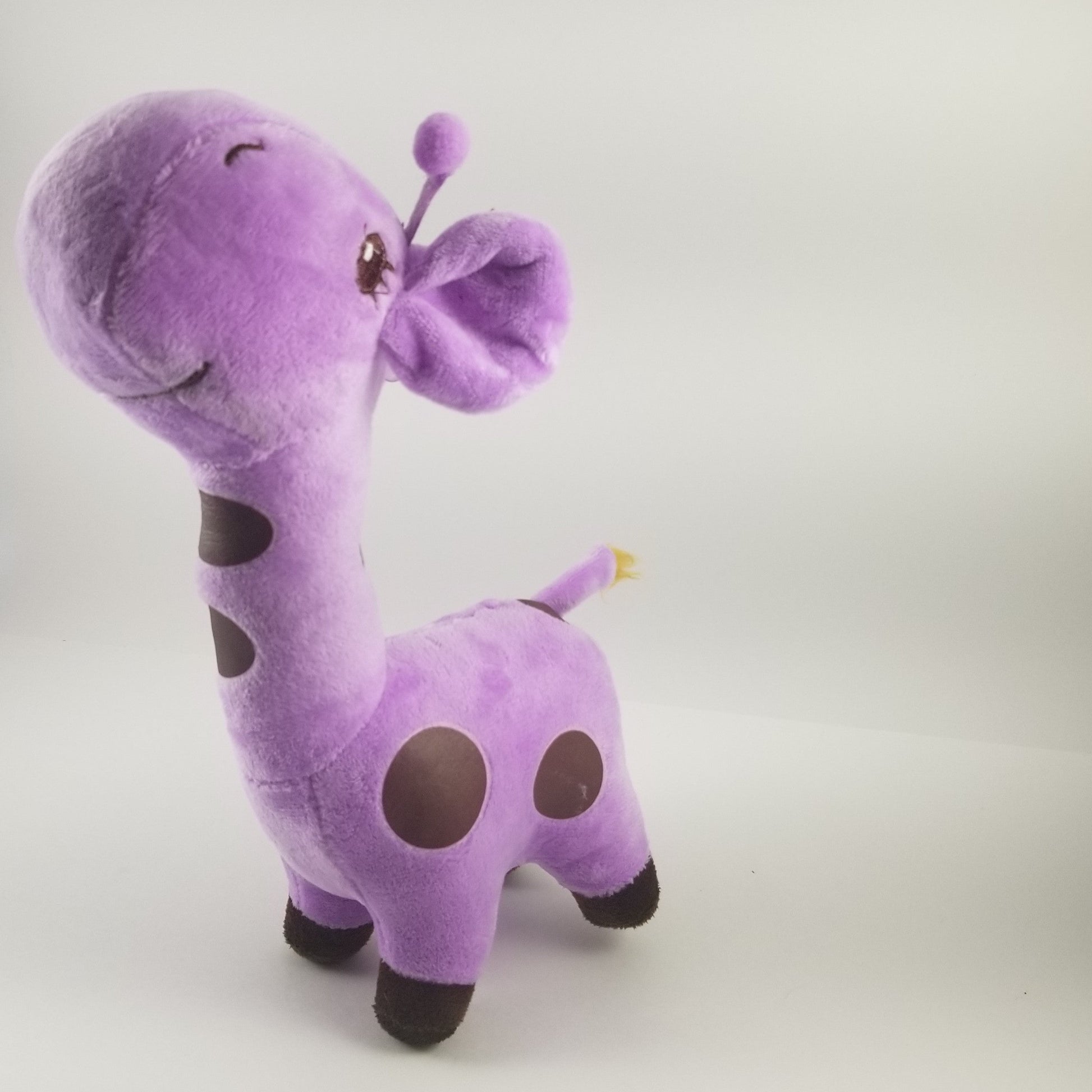 Purple plush giraffe toy on a light gray background